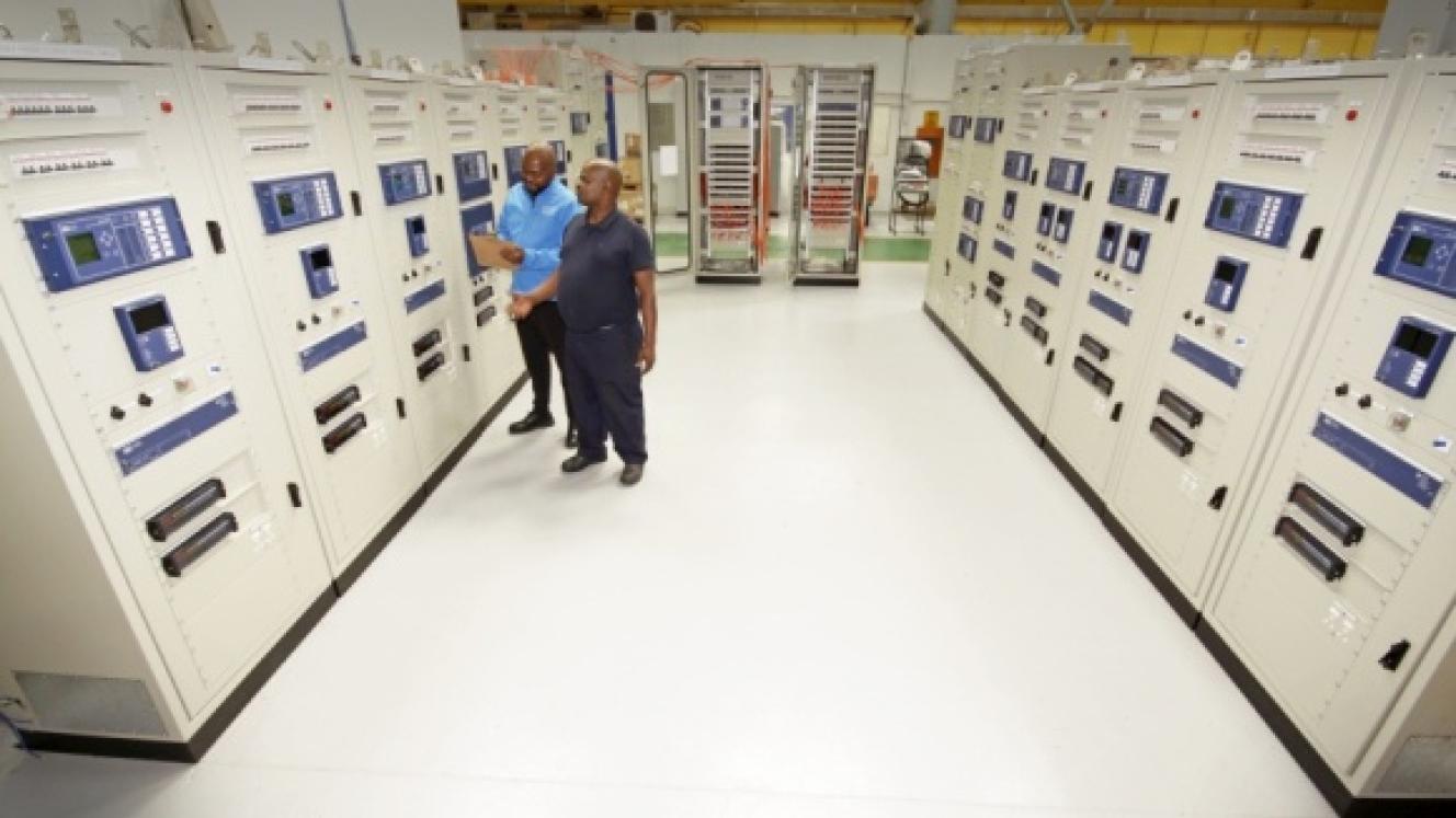 ACTOM P&C staff Vusi Dlamini (left) and David Vilakazi inspect protection and control panels during factory acceptance testing for the Sekelduin digital substation project.