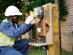 A technician works on distribution equipment.